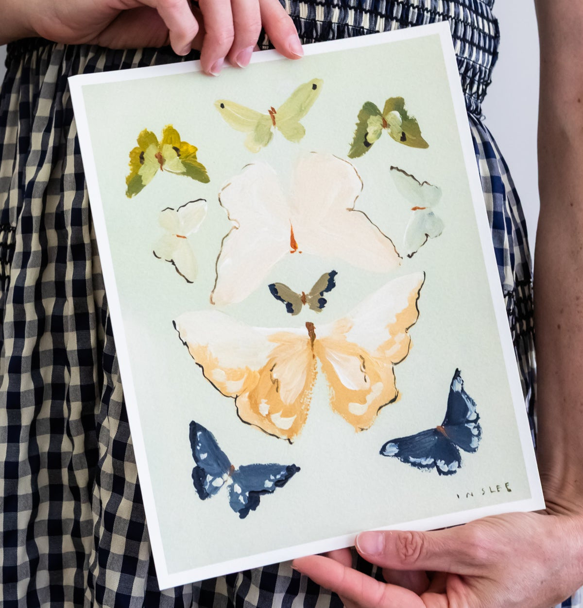 Person holding a card with butterfly and flower design
